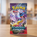 A Pokémon Trading Card Game booster pack for Scarlet & Violet Temporal Forces stands upright on a wooden table with a blurred indoor background.